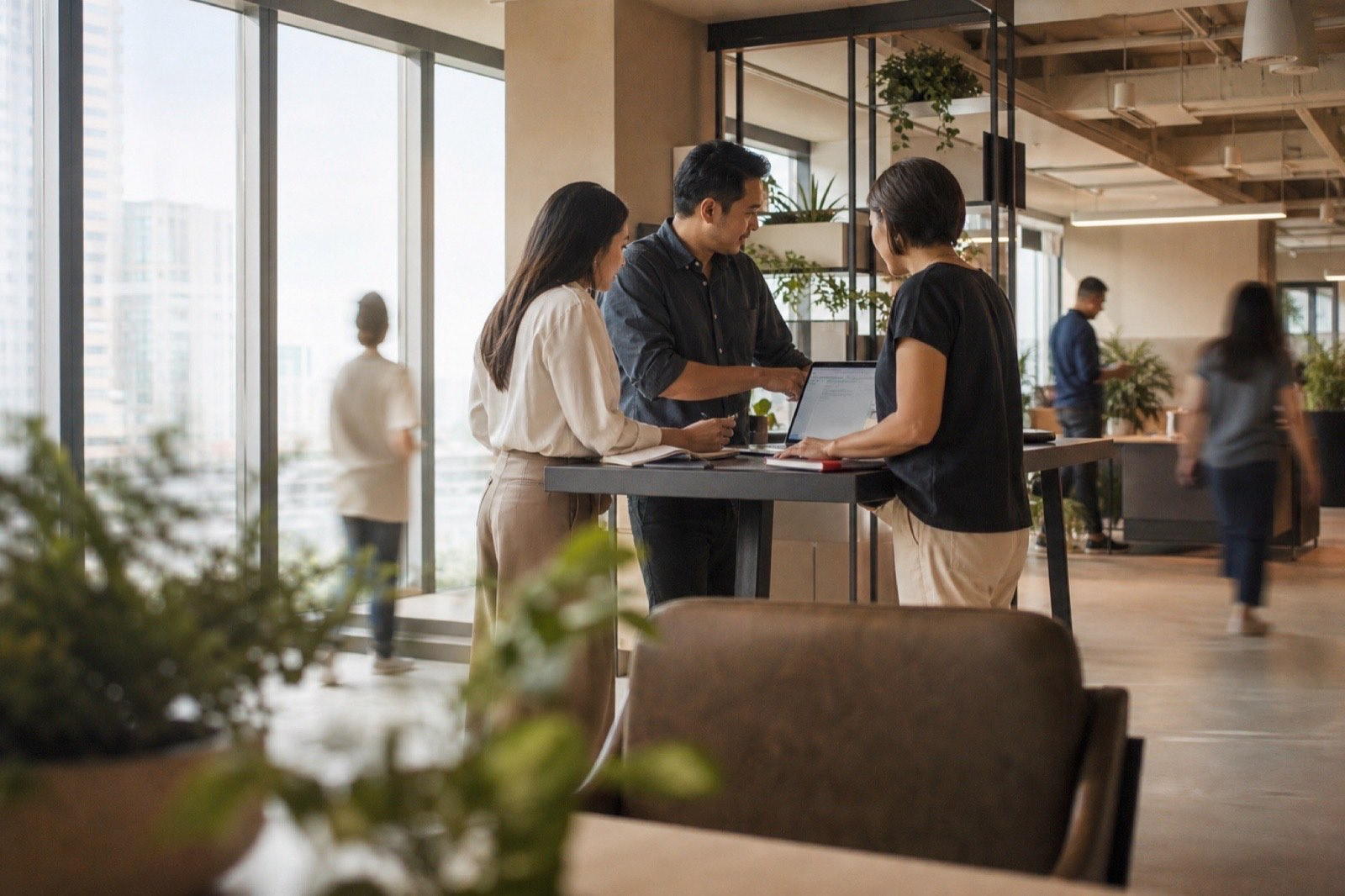 A Filipino team working together around a laptop in a bright office